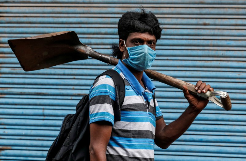 A migrant worker wearing a protective face mask goes to work after few restrictions were lifted, during an extended nationwide lockdown to slow the spread of the coronavirus disease (COVID-19), in Kochi, India, June 1, 2020. REUTERS/Sivaram V