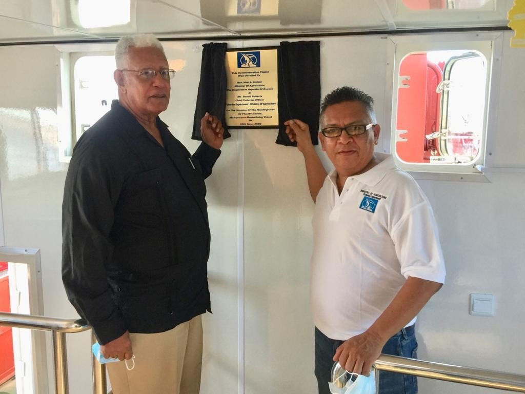 Minister of Agriculture, Noel Holder and another official commission the new vessel