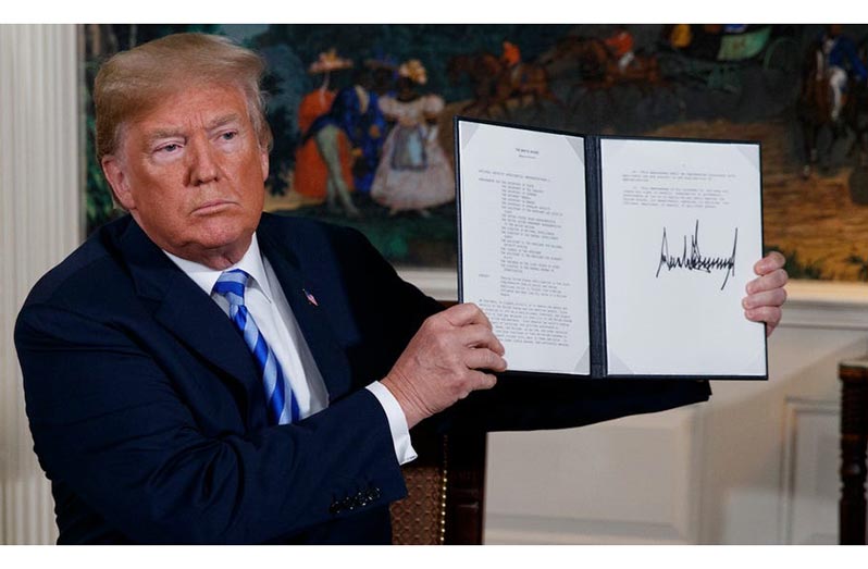 President of the US Donald Trump holds up a copy of the memorandum he signed to withdraw the US from the Iran nuclear deal.