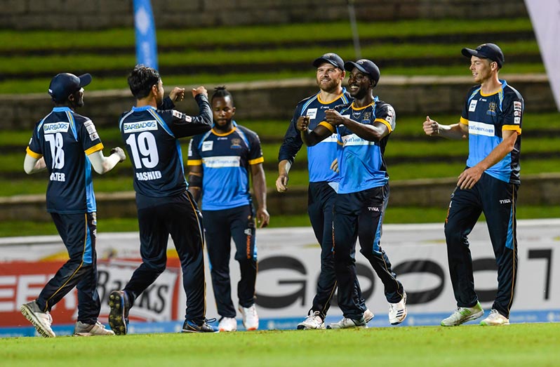 Barbados Tridents players celebrate the fall of a wicket