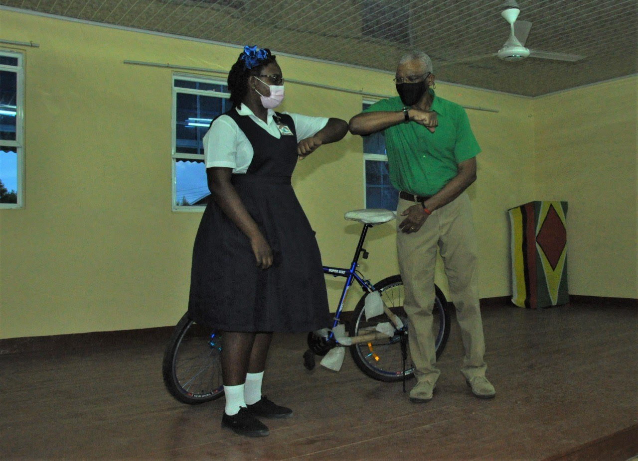 PNC Leader presents a bicycle to Grace Brown of Queenstown Village