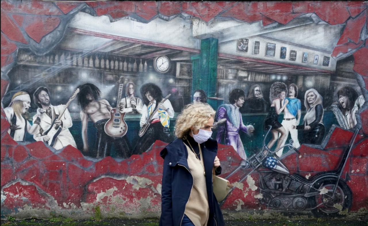 FILE PHOTO: A woman walks past a wall mural during the resurging coronavirus outbreak in Galway, Ireland, October 20, 2020. REUTERS/Clodagh Kilcoyne