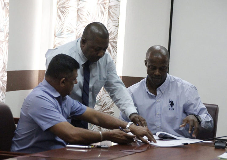 Then Permanent Secretary, Alfred King (right) prepares to sign the contract with CEO of BK International Inc. Mr. Brain Tiwari (left) in January 2020. (Kaieteur News photo)