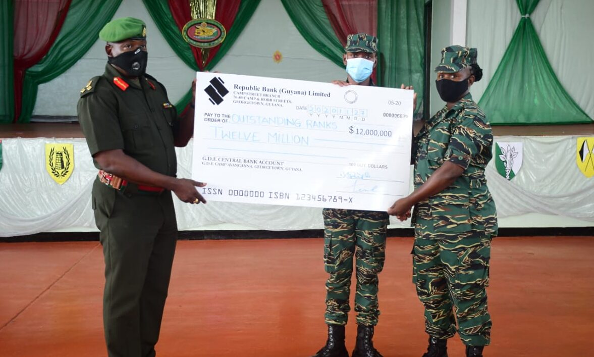 Chief of Staff Brigadier, Godfrey Bess hands over a presentation cheque to soldiers at the ceremony