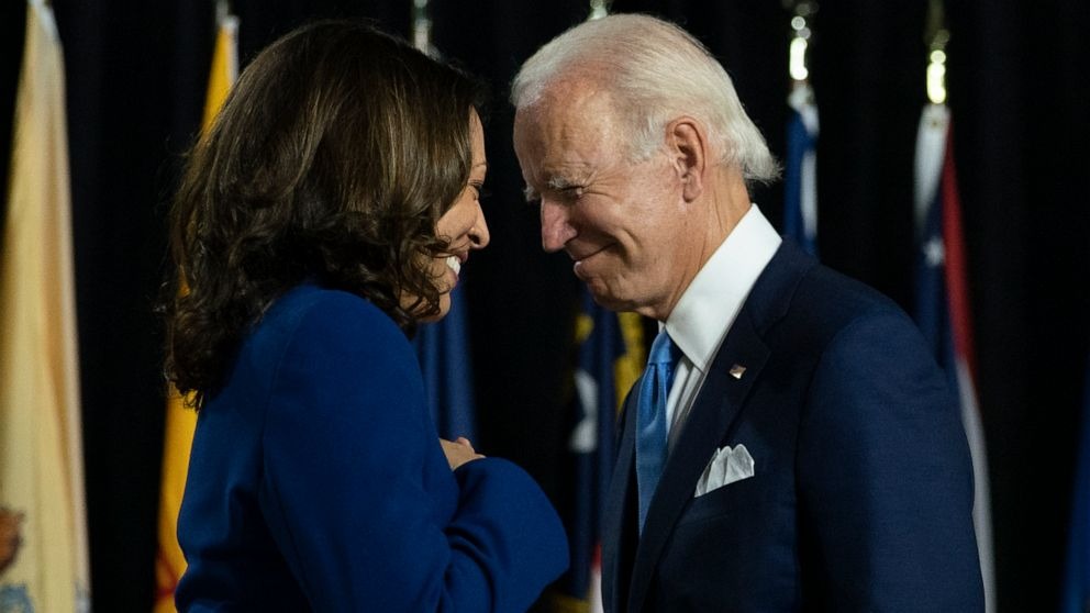 Carolyn Kaster/AP
Democratic presidential candidate former Vice President Joe Biden and his running mate Sen. Kamala Harris, D-Calif., pass each other as Harris moves to the podium to speak during a campaign event at Alexis Dupont High School in Wilmington, Del., Wednesday, Aug. 12, 2020.