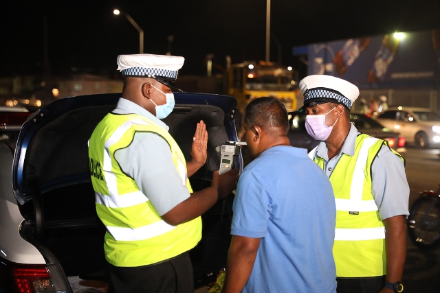 Two Traffic Policemen conduct a breathalyser test on this driver during a road safety education enforcement exercise held on November 6, 2020.