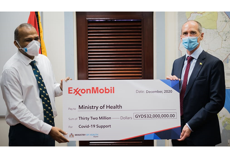 President of ExxonMobil Guyana, Alistair Routledge (right) presents the cheque to Minister of Health, Dr. Frank Anthony