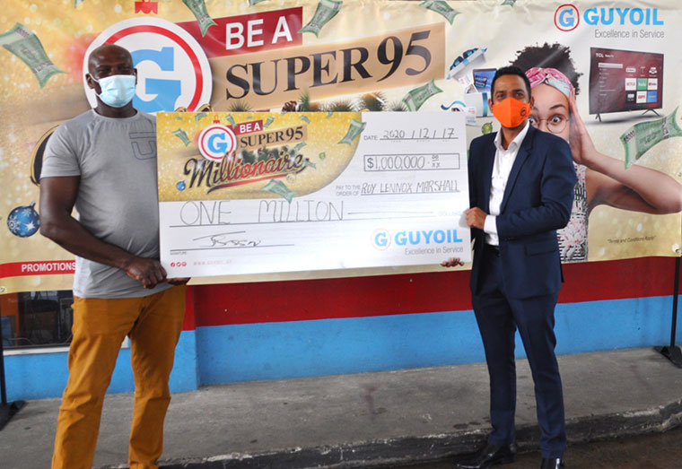 GUYOIL's General Manager Trevor Bassoo presents the $1M cheque to GUYOIL’S first Super 95 Millionaire Roy Marshall