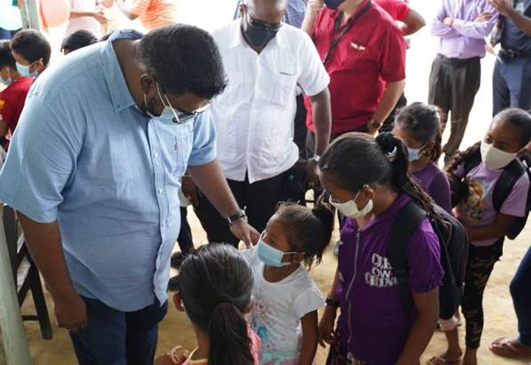 President Irfaan Ali interacts with a little girl during his visit to Kato (DPI)