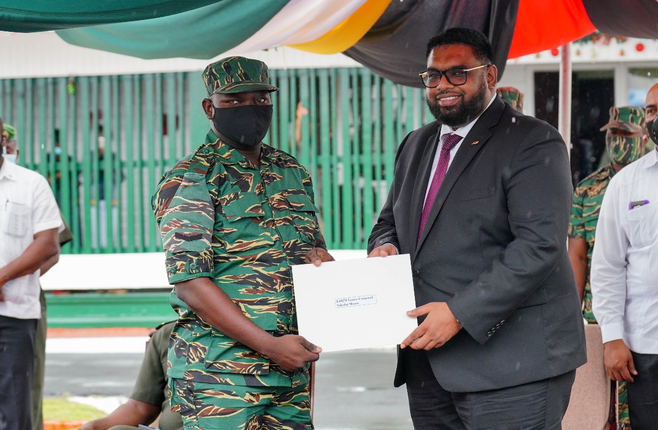 President Irfaan Ali presents a soldier with a scholarship to study at the University of Guyana (OP)