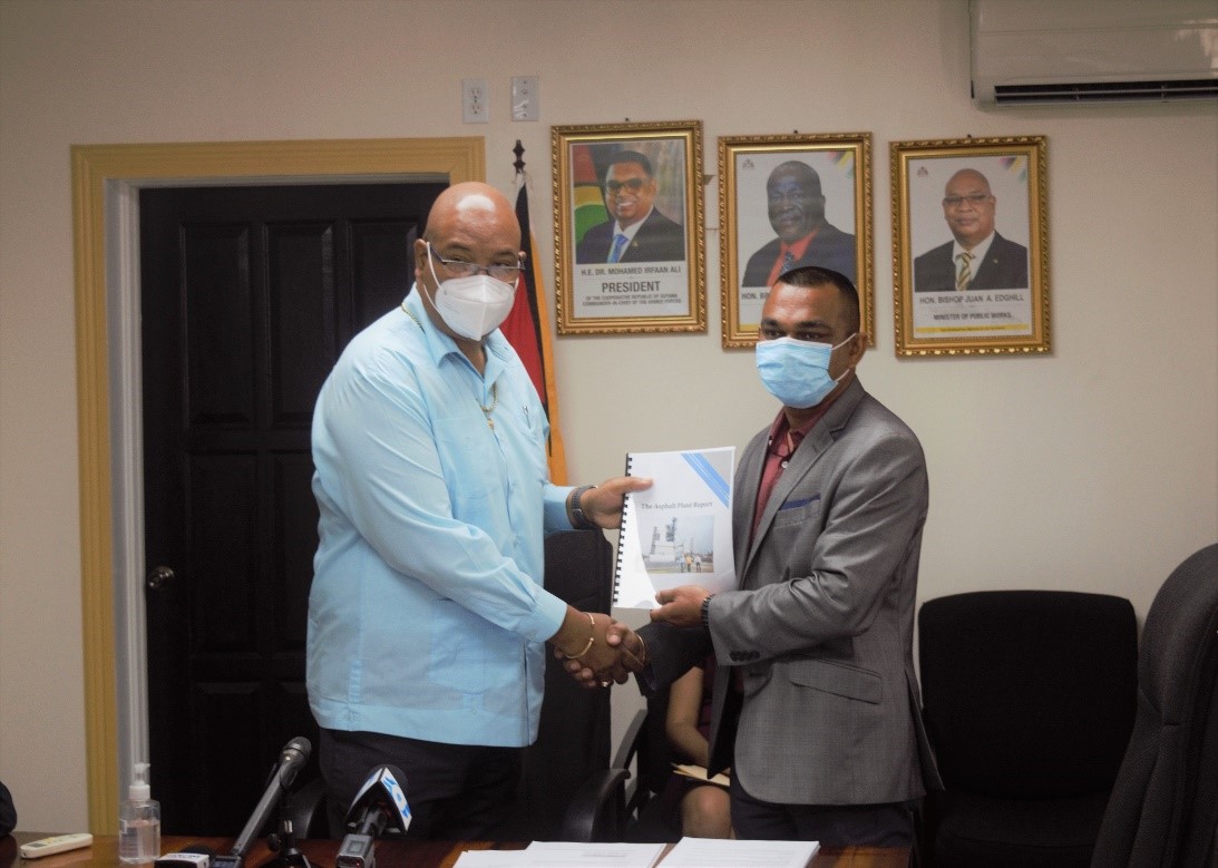 Minister of Public Works, Bishop Juan Edghill receiving the report on the investigations into the Asphalt Plant from Chartered Accountant Chateram Ramdihal