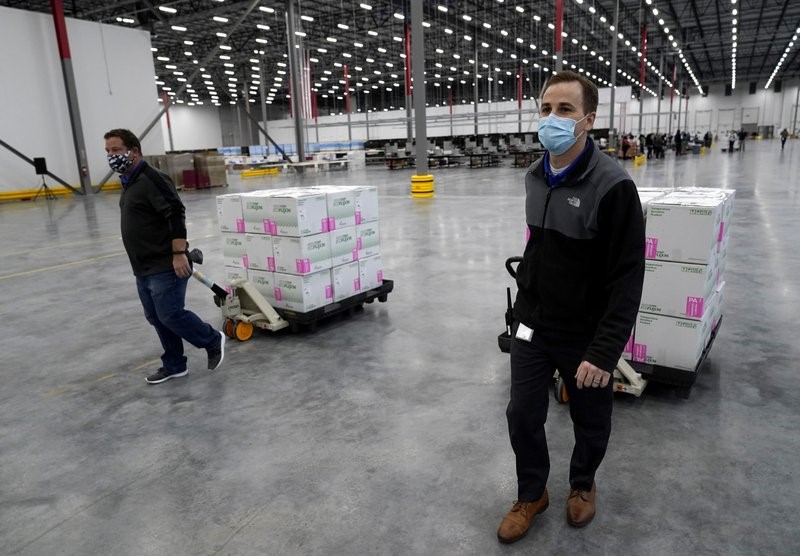 Boxes containing the Moderna COVID-19 vaccine are moved to the loading dock for shipping at the McKesson distribution center in Olive Branch, Miss., Sunday, Dec. 20, 2020. (AP Photo/Paul Sancya, Pool)