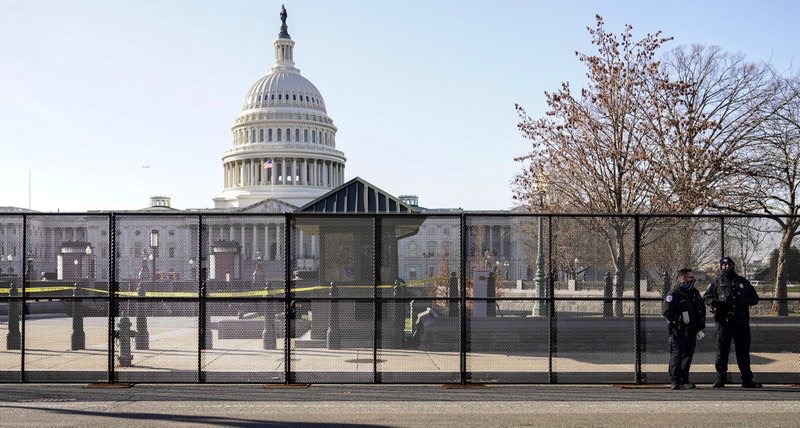 Police officers stand outside of fencing that was installed around the exterior of the Capitol grounds, Thursday, Jan. 7, 2021 in Washington. (AP Photo/John Minchillo)