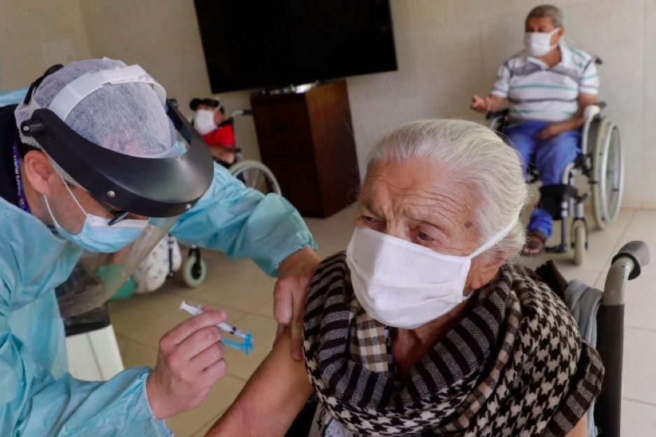 Francisca Alves Xavier, 102, gets a shot of China’s Sinovac CoronaVac vaccine during a priority vaccination programme for the elderly at Bezerra de Menezes Asylum in Brasilia on January 22 [Eraldo Peres/AP Photo]