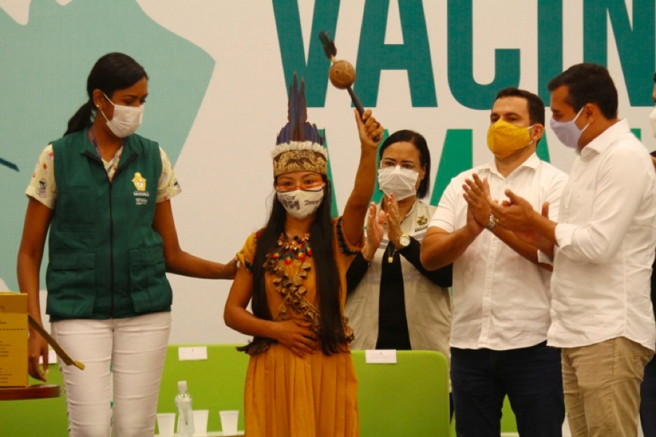 Health worker Vanda Ortega, from the Witoto Indigenous group, celebrates after receiving the COVID-19 vaccine during the start of the vaccination programme in Manaus [Edmar Barros/AP Photo]