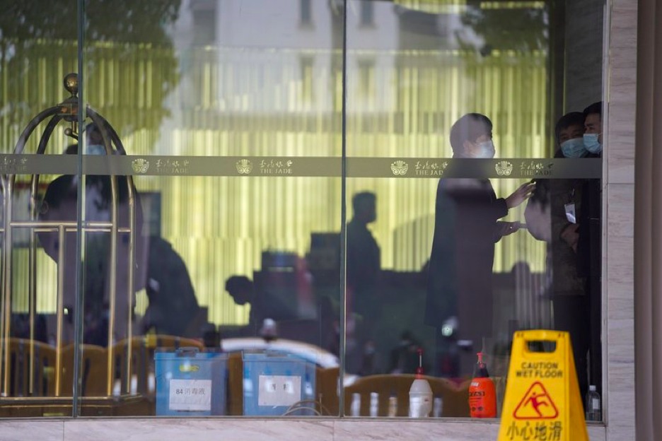 Workers are seen inside hotel where a team of experts from the World Health Organization are quarantined in Wuhan in centra China's Hubei province on Thursday, Jan. 28, 2021. A World Health Organization team has emerged from quarantine in the Chinese city of Wuhan to start field work in a fact-finding mission on the origins of the virus that caused the COVID-19 pandemic. (AP Photo/Ng Han Guan)