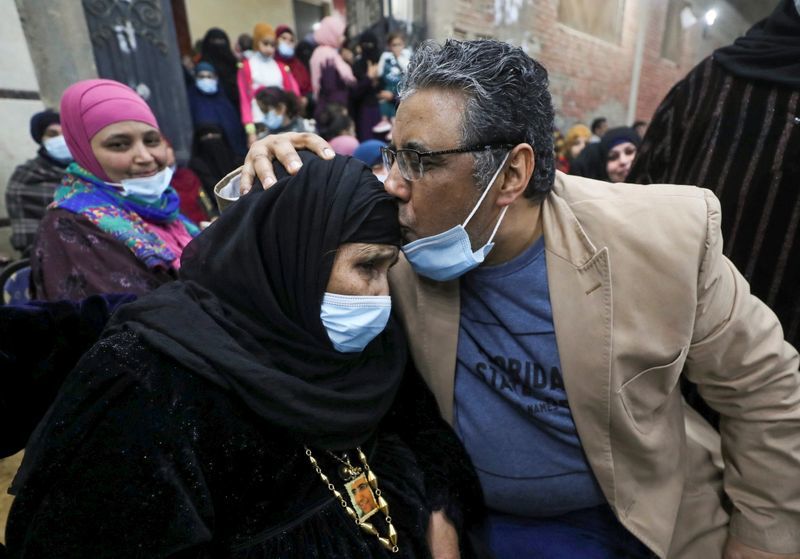Journalist Mahmoud Hussein kisses his mother after being released by Egyptian authorities after four years in detention on accusations of publishing false news, in Abou Al Nomros, in Giza, Egypt February 6, 2021. REUTERS/Mohamed Abd El GhanyREUTERS