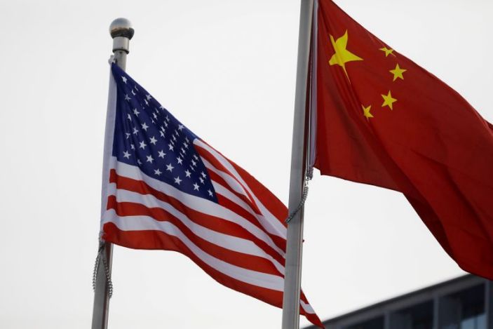 FILE PHOTO: Chinese and U.S. flags flutter outside the building of an American company in Beijing, China January 21, 2021. REUTERS/Tingshu Wang