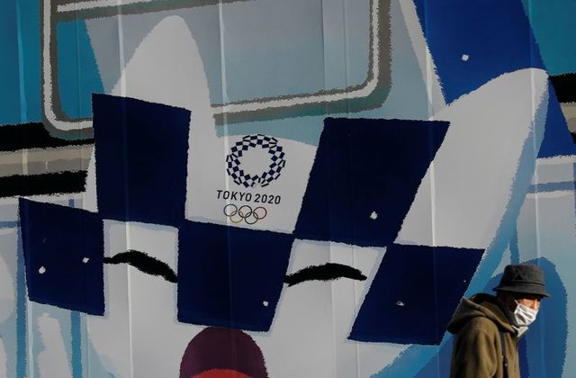 FILE PHOTO: A man wearing a protective face mask walks in front of a wall decoration featuring Tokyo 2020 Olympic Games mascot Miraitowa amid the coronavirus disease (COVID-19) outbreak in Tokyo, Japan, February 3, 2021. REUTERS/Kim Kyung-Hoon