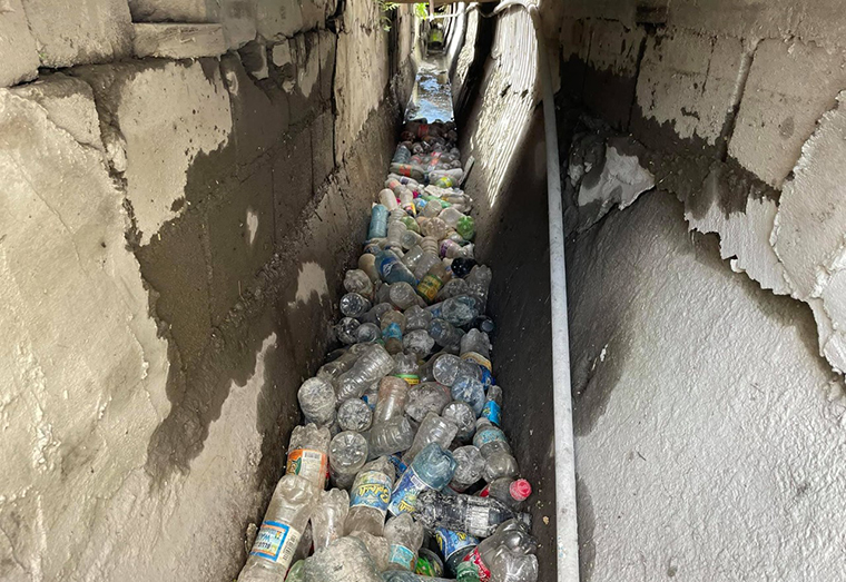 Scores of plastic bottles stuck in a drain in Guyana (Darrell Carpenay photo)