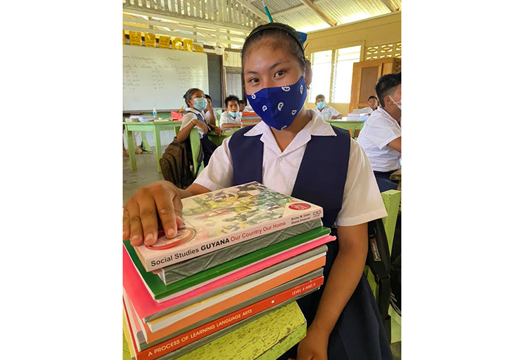 A student of the Aishalton Primary School in Region Nine along with her NGSA study package provided by the Ministry of Education.