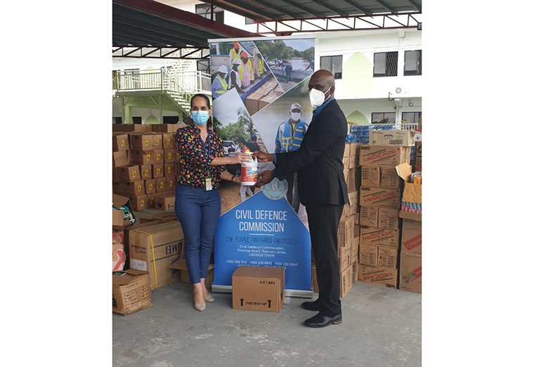 Head of the Consumer Goods Division, Anjeta Hinds of ANSA McAl hands over the items to Director General of CDC, Kester Craig
