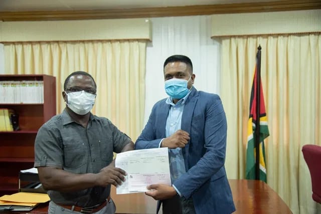 Minister of Local Government and Regional Development, Nigel Dharamlall hands over a subvention cheque to representatives of the Industry/Plaisance NDC
