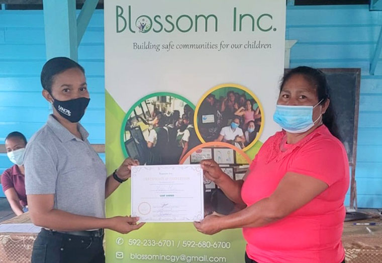 Education and Awareness
 Officer , Arlyne Ramdatt presents a certificate to a resident of Waramadong following a training exercise undertaken by Blossom Inc through its Spotlight Initiative project.