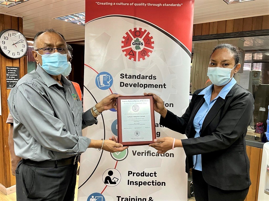 Factory Manager of Gafsons Industries Limited Bharath Rampersad receives a plaque from Head of the GNBS’ Certification Services Department Andrea Mendonca on July 12, 2021.