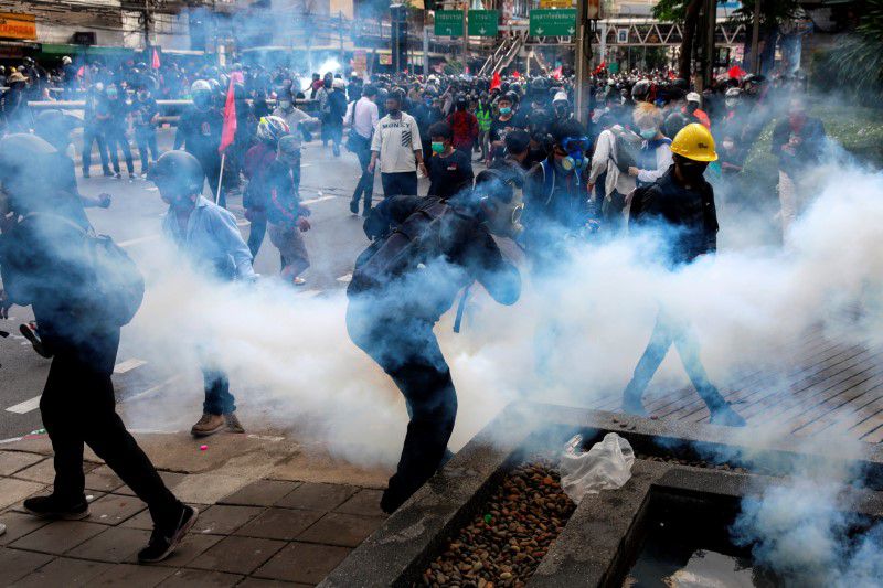 Demonstrators react to tear gas during a clash with police at a protest against what they call the government's failure in handling the coronavirus disease (COVID-19) outbreak, in Bangkok, Thailand, August 7, 2021. REUTERS/Soe Zeya Tun