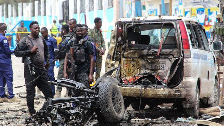 Security officers patrol on the site of a car-bomb attack in Mogadishu.