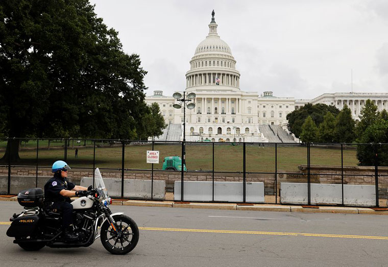 A U.S. Capitol Police officer patrols the unscalable fence erected around the Capitol ahead of an expected rally Saturday in support of the Jan. 6 defendants in Washington, U.S. September 17, 2021. REUTERS/Jonathan Ernst