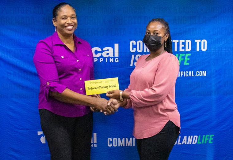 Country Manager Tropical Shipping, Ms. Glenis Hodge seen presenting to Graduate DHM, Kizzy Howell of Redeemer Primary School.