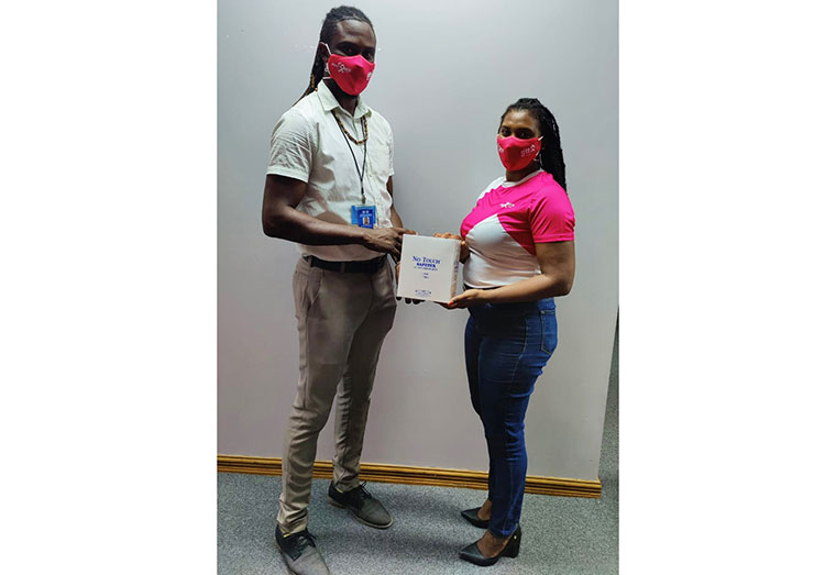 GTT Pinktober Coordinator, Diana Gittens hands over pap smear kit donation to National VIA Coordinator at the Ministry of Health, Dr. Martin Campbell
