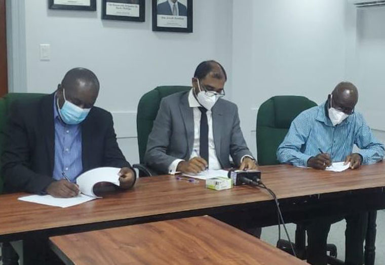 Sol Guyana General Manager Earl Carribon (L) and Guyana General Workers’ Union President Norris Witter (R) signing the new two-year Memorandum of Agreement in the presence of the Chief Labour Officer (CLO) Dhaneshwar Deonarine