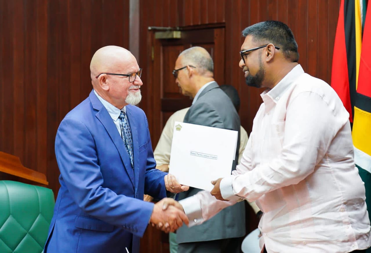 President Irfaan Ali presenting the Chairman of the Police Service Commission, Bishop Patrick Findlay with his letter of appointment at the Office of the President on Tuesday