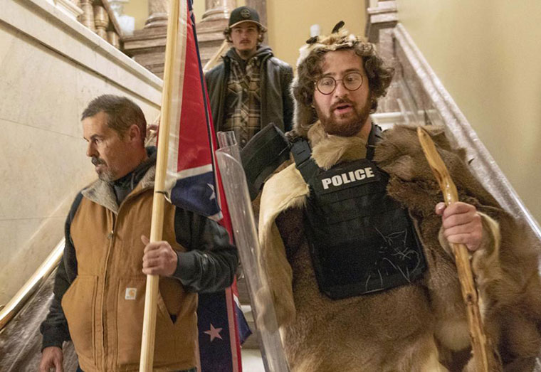 Supporters of President Donald Trump, including Aaron Mostofsky, right, who is identified in his arrest warrant, walk down the stairs outside the Senate Chamber in the U.S. Capitol, in Washington, Jan. 6, 2021. Mostofsky, the son of a New York judge, who referred to himself as a "caveman" eager to protest Donald Trump's presidential election loss, was sentenced on Friday, May 6, 2022, to eight months in prison. U.S. District Judge James Boasberg told Mostofsky that he was "literally on the front lines” of the mob's attack on Jan. 6, 2021. (AP Photo/Manuel Balce Ceneta, File)