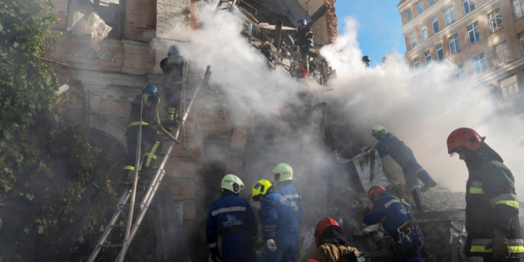 Firefighters work after a drone fired on buildings in Kyiv, Ukraine, Monday, October 17, 2022. (AP Photo/Roman Hrytsyna)