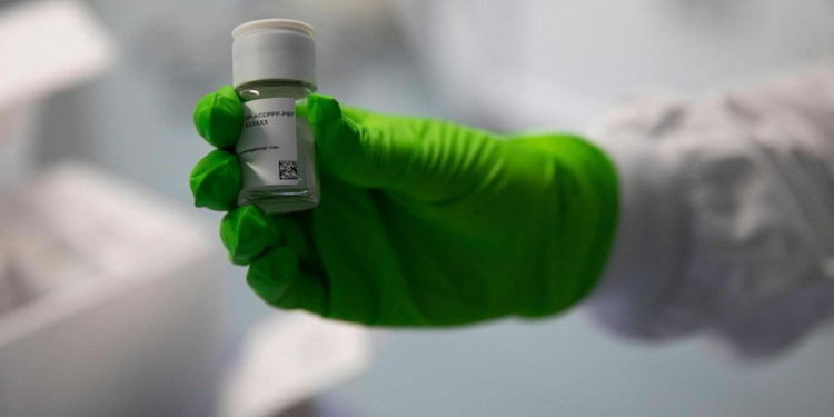 An employee holds up a vial of an oncological product under development, at the BioNTech research institute in Mainz, Rhineland-Palatinate, western Germany, on Oct. 5, 2022.