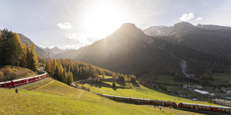 A train of the Rhaetian Railway (RHB) is on its way to set a world record for longest passenger train, on Saturday, October 29, 2022, in Berguen, Switzerland. The 1.91 kilometer long train is on a journey on the UNESCO world heritage track from Preda to Alvaneu. The train consists of 100 wagons. The old world record of 1732,9 meters dates back to 1991. (Yanik Buerkli/Keystone via AP)