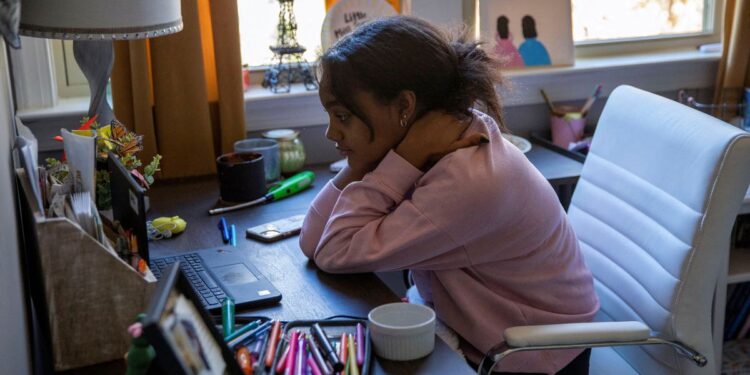 Fulton County Public Schools 8th grader Ceani Williams participates in an online class during a virtual learning day at a desk in her bedroom in Milton, Georgia, U.S., January 4, 2022, after students have gone remote for a week as cases of the Omicron coronavirus variant continue to surge. REUTERS/Alyssa Pointer/File Photo