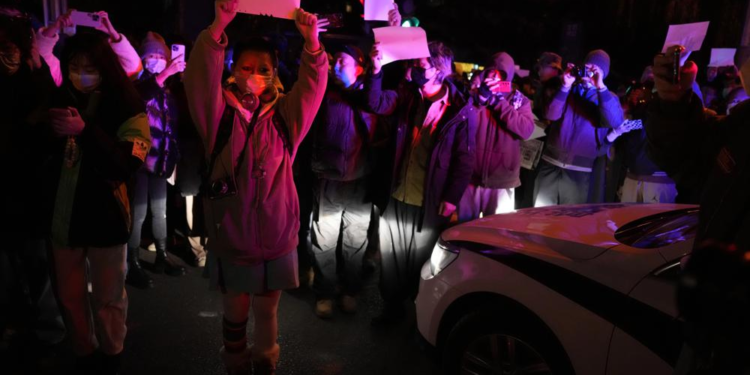 Protesters hold up blank papers and chant slogans as they march in protest in Beijing, Sunday, Nov. 27, 2022. Protesters angered by strict anti-virus measures called for China's powerful leader to resign, an unprecedented rebuke as authorities in at least eight cities struggled to suppress demonstrations Sunday that represent a rare direct challenge to the ruling Communist Party. (AP Photo/Ng Han Guan)