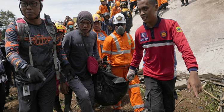 Rescuers carry the body of an earthquake victim recovered from under the rubble of a collapsed building in Cianjur, West Java, Indonesia, November 22, 2022. /CFP