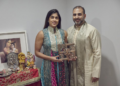 Sheetal Deo and her husband, Sanmeet Deo, hold a Hindu swastika symbol in their home in Syosset, N.Y., on Sunday, Nov. 13, 2022. Hindus, Buddhists and Native Americans are trying to rehabilitate the swastika, a symbol of peace and prosperity, and to restore it to a place of sanctity in their faiths. (AP Photo/Andres Kudacki)
