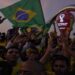 Fans cheer and wave Brazilian flags in front of the World Cup countdown clock in Doha, Qatar, Friday, Nov. 18, 2022. Fans poured into Qatar on Friday ahead of the Middle East's first World Cup as Doha ordered beers not to be poured out at stadiums during the tournament — a last-minute surprise largely welcomed by the country's conservative Muslims and shrugged off by giddy fans. (AP Photo/Jon Gambrell)