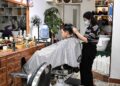 A hairdresser cuts a customer's hair at a hair salon in Liwan District of Guangzhou, capital of south China's Guangdong Province, Dec. 1, 2022. (Xinhua/Deng Hua)