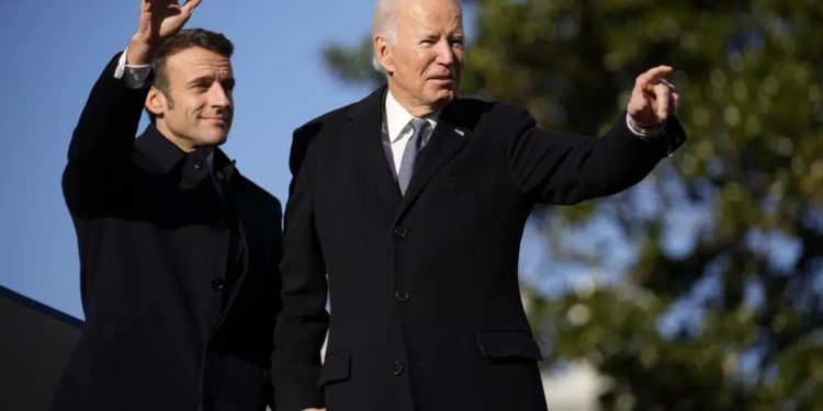President Joe Biden and French President Emmanuel Macron stand on the stage during a State Arrival Ceremony on the South Lawn of the White House in Washington, Thursday, Dec. 1, 2022. (AP Photo/Andrew Harnik)