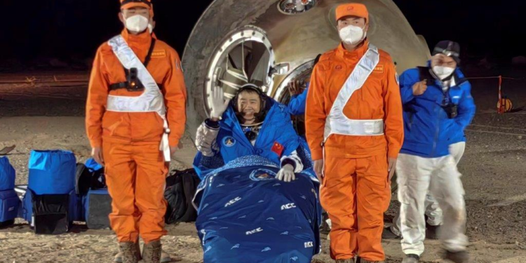 In this photo released by Xinhua News Agency, astronaut Chen Dong waves as he sits outside the re-entry capsule of the Shenzhou-14 manned space mission after it lands successfully at the Dongfeng landing site in northern China's Inner Mongolia Autonomous Region, Sunday, December 4, 2022. (Li Gang/Xinhua via AP)