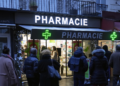 FILE - People wait in front of a pharmacy to get a COVID-19 test in Paris, France, Sunday, January 9, 2022. On Friday, December 9, 2022, President Emmanuel Macron announced France will make condoms free in pharmacies for anyone up to age 25 in the new year. (AP Photo/Francois Mori, File)