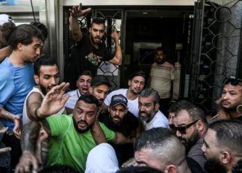 Lebanese activists gather outside a local bank in support of Abed Soubra, who stormed the branch demanding access to his own accounts, in Beirut on Sept 16. Lebanese police detained Soubra after he entered the bank and, armed with a gun, demanded access to his deposits. It was the third such incident in Lebanon that week alone. Marwan Naamani/Picture Alliance/Getty Images